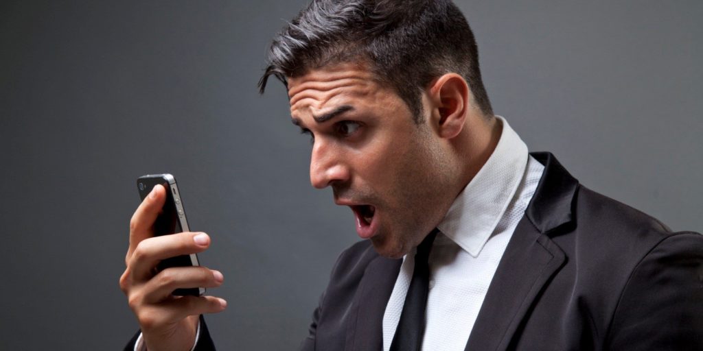 man looking shocked on his cell phone